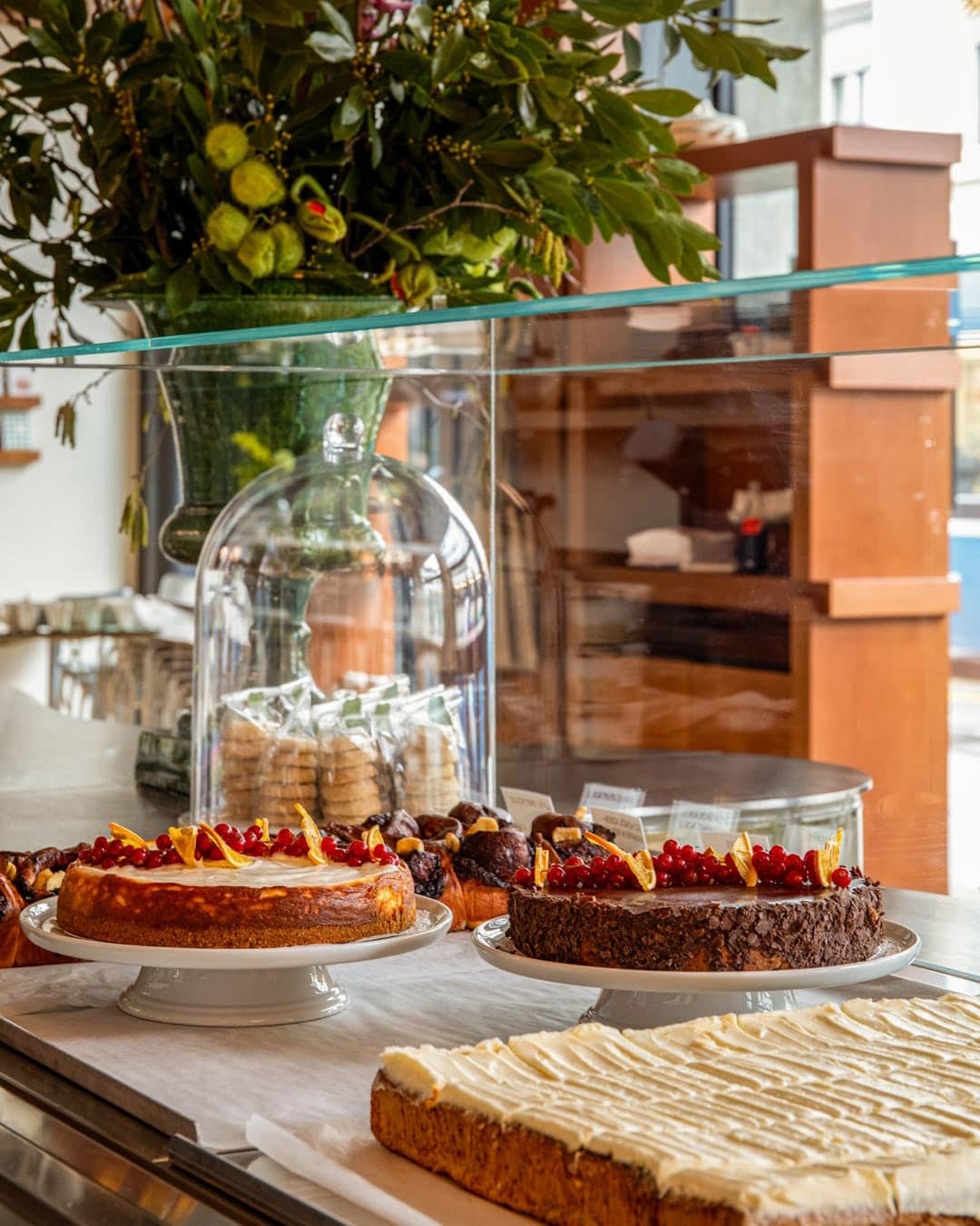 Käsekuchen mit Johannisbeeren, Schokoladenkuchen und Karottenkuchen unter Glas
