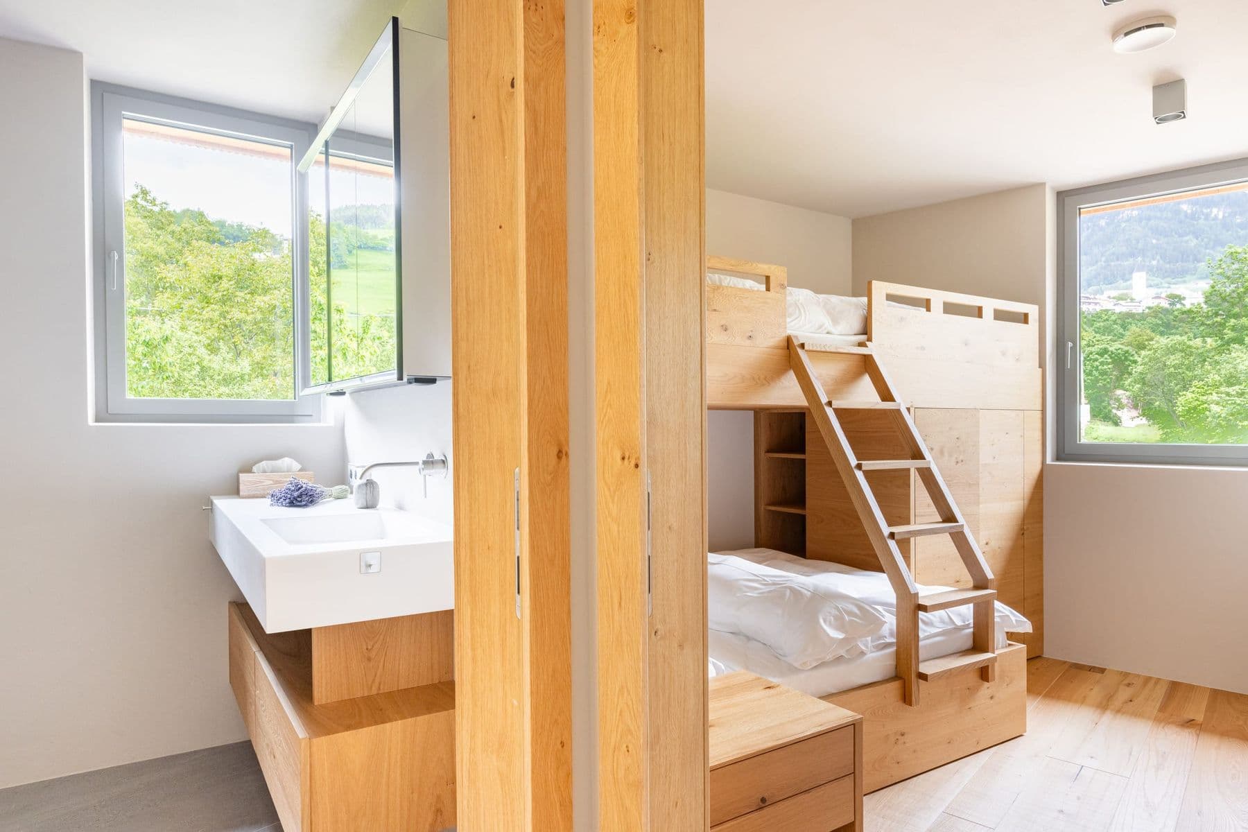 Zimmer mit Etagenbett aus Holz und Lavabo