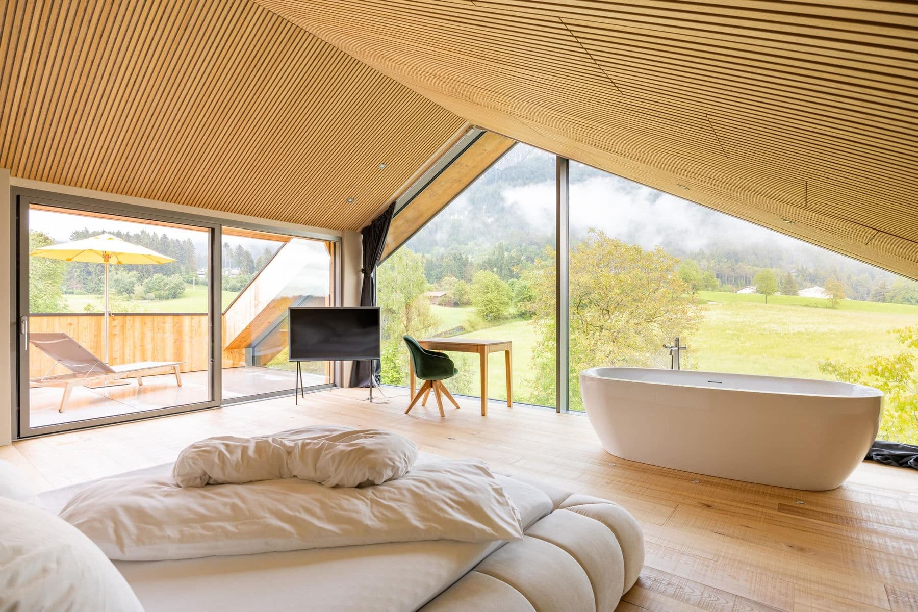 Dachzimmer mit freistehender Wanne, Glasfront und Terrasse